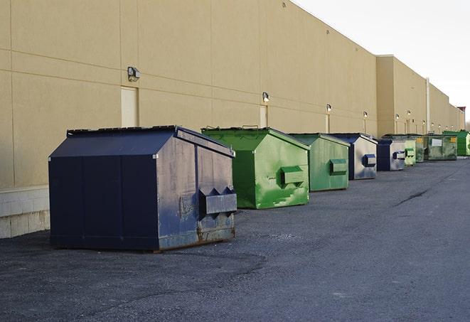 a row of yellow and blue dumpsters at a construction site in Agawam, MA